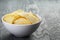 Rippled organic chips in white bowl on wooden