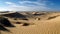 Rippled sand dunes in arid Africa gleaming blue generated by AI