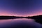 Ripples on a lake at sunrise with star filled purple sky