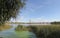 Ripples on the river at sunny summer day. Reeds and duckweed on the river at sunset. hanging bridge over the river