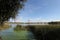 Ripples on the river at sunny summer day.Reeds and duckweed on the river at sunset. hanging bridge over the river