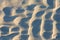 Ripples in the sand left by waves on a beach in England