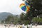 On the rise in the sky large parachute in the blue sky tropical beach. Two Chinese tourists flying on a parachute over the sea on