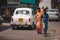 Rishikesh. India. April 12, 2017: Two guys walk along Rishikesh street amid passing taxi cars