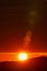 Rising of the sun in mountains, red sun disk rises from tops of mountain range. Beautiful natural lens flare in orange