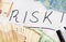 `RISK` inscription written in black marker on white and Euro banknotes .. Business concept.