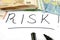 `RISK` inscription written in black marker on white and Euro banknotes .. Business concept.