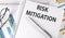 RISK MITIGATION text , pen and glasses on the chart,business concept