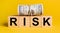 RISK with money on a yellow background. The concept of business, finance, credit, income, savings, investments, exchange, tax