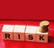 Risk Word On wood blocks and stack of coins on red . Business risks concept