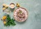 Risotto of chanterelles on a beige porcelain plate on a pistachio concrete table