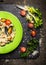 Risotto with mussels, lettuce and tomatoes on dark slate