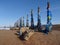 Ritual Buryat pillars on the background of sand snow and blue sky