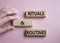 Rituals and Routines symbol. Concept words Rituals and Routines on wooden blocks. Doctor hand. Beautiful pink background.