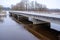 River Aiviekste in Vidzeme, Latvia in winter time. High water level in the river, dark January day. Bridge over the