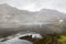 A river on the Atlantic with mountains and boats mystical in the fog.