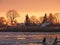 River Atmata , homes and snowy trees in sunset colors, Lithuania