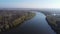 River with banks with trees among flood meadows, aerial view