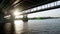 River barge sails under the bridge over the Dnieper in Kiev. Urban summer landscape.