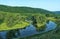 River bend with forest islands in middle of forest slopes