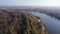 River bend overgrown with trees among flood meadows, aerial view