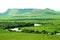 The river bends through a green fertile valley at the foot of a high flat mountain