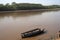 River Boats tied up to pier river bank with view to other shore in Puerto Maldonado in Peru and the Amazon