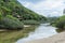 River with a brackish water that passes by the side of a mountain