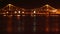 River bridge traffic at night, shining reflections, ferry boats