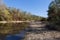 River with bright trees on the shore on a clear autumn day. Autumn landscape.