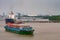 River container boat in front of Phuoc Khanh petroleum port along Long Tau River, Vietnam