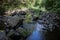 River course littered with rocks with waterfall