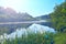 River is covered with fog at dawn. Forest is reflected in the river in summer