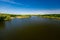 River creek surrounded by green woods. Water landscape