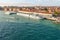 A river cruise boat docks at a port in Venice with the large cruise ships seen in the distance behind at the main ship port.