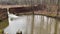 A river dam and pan of a flowing river through the forest in the fall