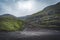 River delta with black sand beach, rocks and high cliffs in Faroe islands, close to village Saksun in Faroese island