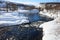 River flowing across stones snow and trees in polar city