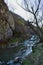 River flowing at the edge of the rocky mountains in spring season