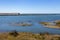 River flowing into the sea. Bay shore on sunny day. Scenic panorama of summer seacoast. Atlantic Ocean coast.