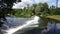 River with flowing water into small dam on a sunny summer day