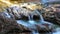 A river flows over rocks in this beautiful scene in the mountains in autumn