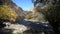 The river flows through the rocks in this beautiful place in the mountains in autumn