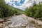 River through forest near the White Mountains, a bridge in background