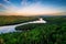 River in a green field under cloudy sky at sunset in Quebec, Canada