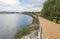 River lake water pier wooden catwalk bank way path cycling track urban park city horizon