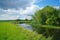 River, land with trees and cloudy sky