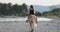 River landscape afternoon. Girl, woman, lady in a DARK DRESS and hat is barefoot. Cowgirl riding horse