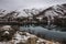 River landscape powdered by snow. Snowy hills reflect in calm water of Snake river. Hells canyon area