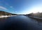 River with lush vegetation on the banks illuminated by bright sunlight. Riviere-Rouge, Quebec.